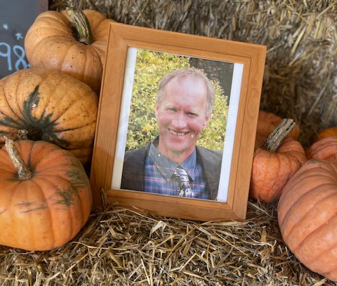 A framed photo of Michael Wilshaw in a pumpkin patch